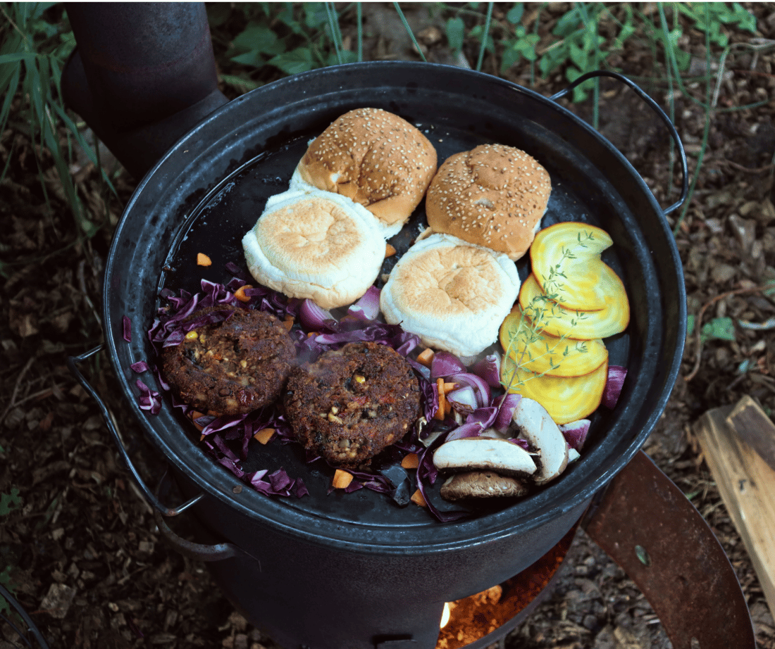 Vegan black bean burgers with cashew nuts on the outdoor cooking stove.